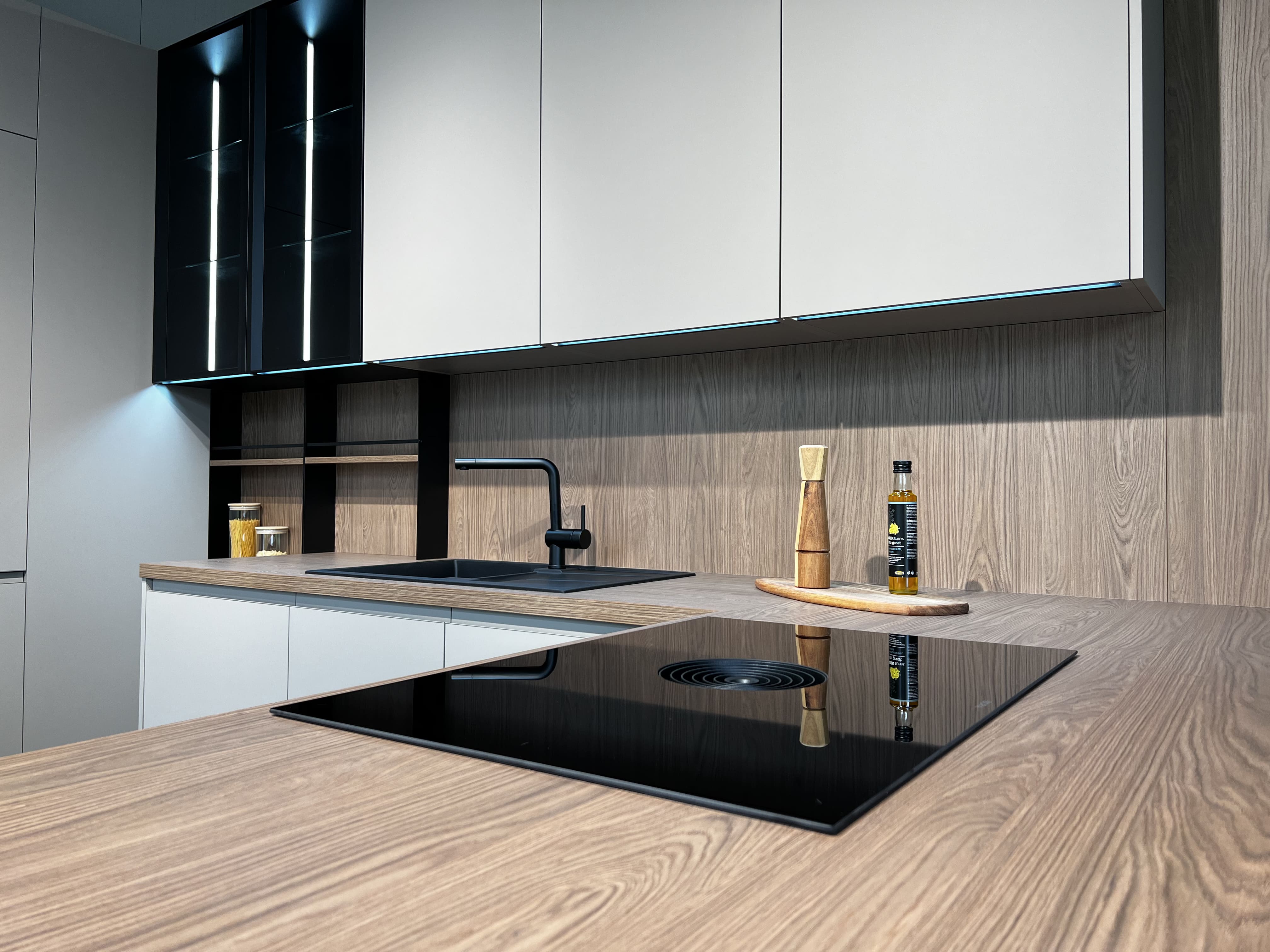Čierna varná doska v rámci kuchyne na mieru ladí so zvyšným vybavením kuchyne v realizácii Dalno Banská Bystrica..